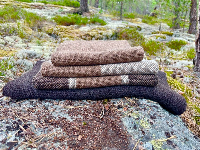Neljä huivia metsässä kiven päällä.