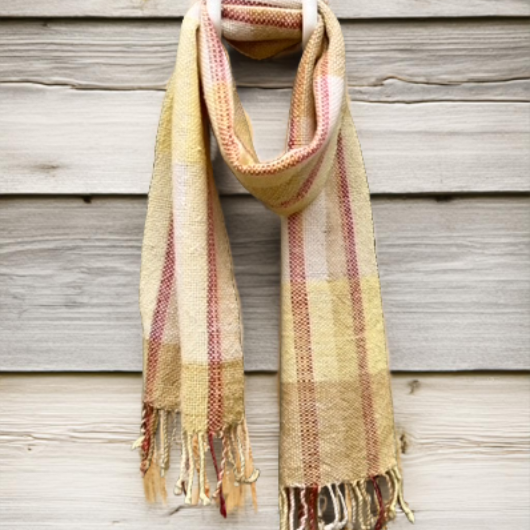 Keltaruudullinen villahuivi ladon seinallä