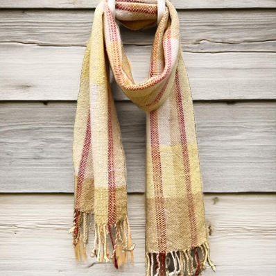 Keltaruudullinen villahuivi ladon seinallä