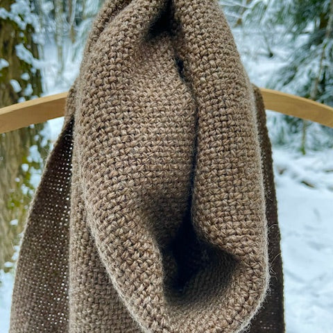 Ruskea villashaali läheltä henkariin kiedottuna. Taustalla talvinen metsä.