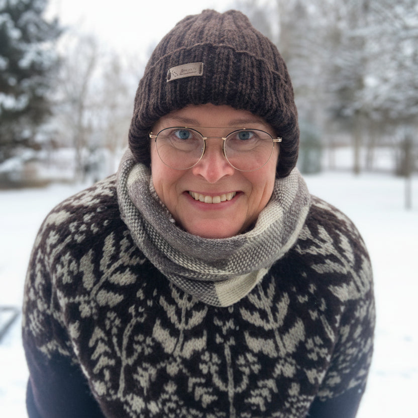 Tummanruskea pipo Hannan päässä edestä kuvattuna, talvinen maisema taustalla.