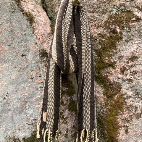 Ruskeabeige pystyraidallinen villahuivi roikkumassa kuten kaulassa.