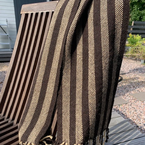 Ruskeabeige villashaali terassituolin selkänojalla.