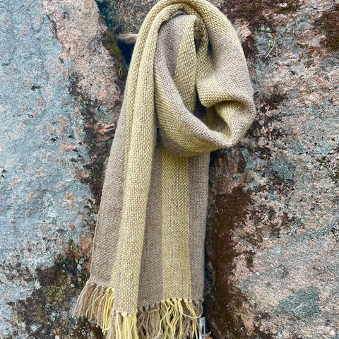 Villashaali – vaaleanharmaa & keltainen roikkumassa kuten kaulassa. Taustalla kallio.