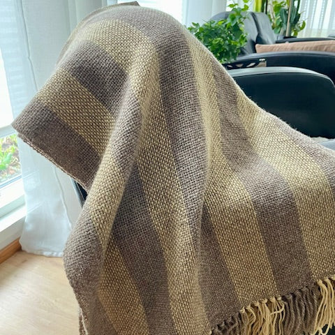 Käsinkudottu villahuivi – vaaleanharmaa & keltainen nojatuolin selkänojalla